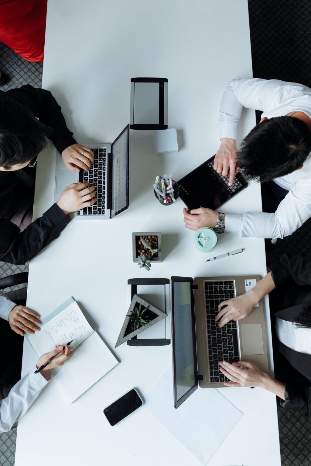 top- down view of a desk with people working on it