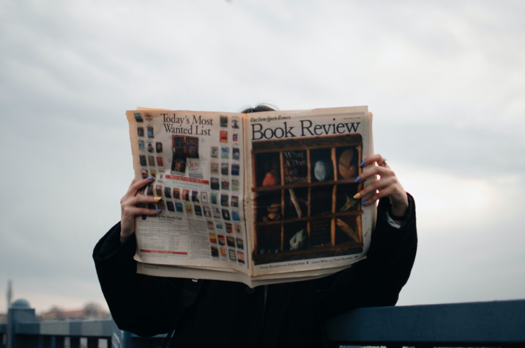 man reading a newspaper review